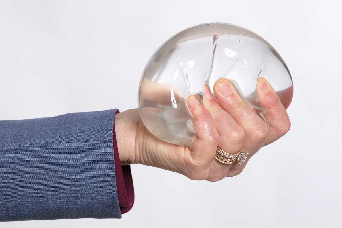 Hand holding a clear, squishy object.