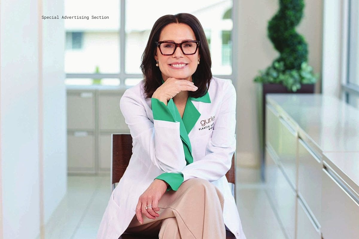 Smiling woman in lab coat, posing confidently.
